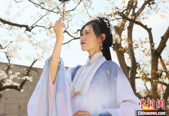 圖為蘭州青年身穿漢服在百年梨園賞景?！「哒?攝