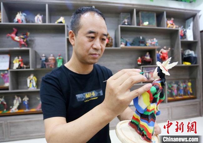 圖為安秋平正在創(chuàng)作代表隴南文縣民俗的《白馬人》作品?！「哒?攝