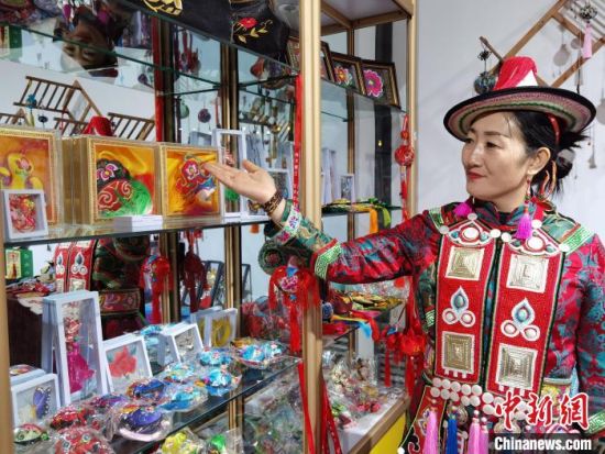 圖為身著民族服飾的隴原巧手展示手工藝品。(資料圖) 徐雪 攝