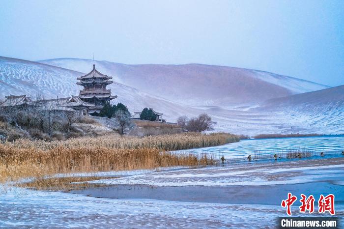 2021年11月28日，雪落鳴沙山月牙泉景區(qū)?！⊥醣筱y 攝
