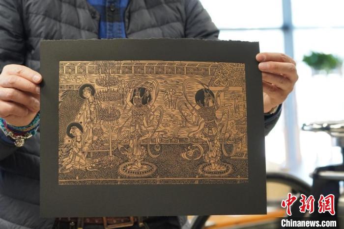 圖為手工書藝人展示敦煌雕版壁畫印刷品?！【琶赖┰?　攝