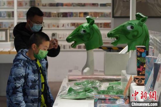 圖為“神馬來(lái)了”銅奔馬頭套吸引參觀者駐足?！【琶赖┰?攝