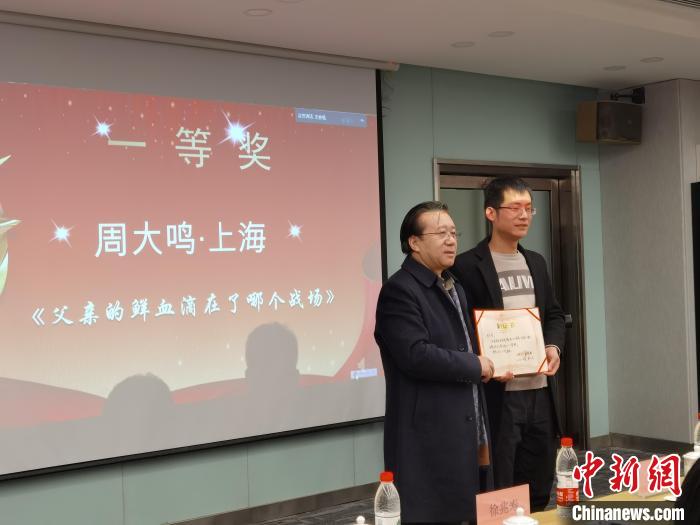 圖為作家、西北師范大學(xué)新聞與傳媒學(xué)院院長徐兆壽頒發(fā)一等獎證書，代領(lǐng)獎?wù)呱吓_領(lǐng)獎?！钅?攝