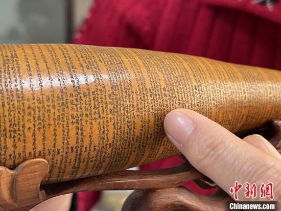 圖為長約二十公分的長條葫蘆雕刻佛教經(jīng)文作品?！堟?攝