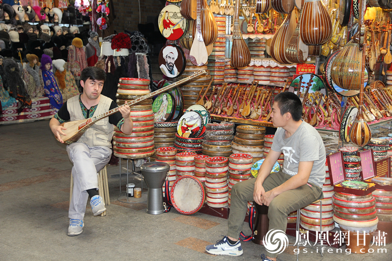 烏魯木齊二道橋巴扎內(nèi)，店主正在向客人展示樂(lè)器。楊文遠(yuǎn) 攝