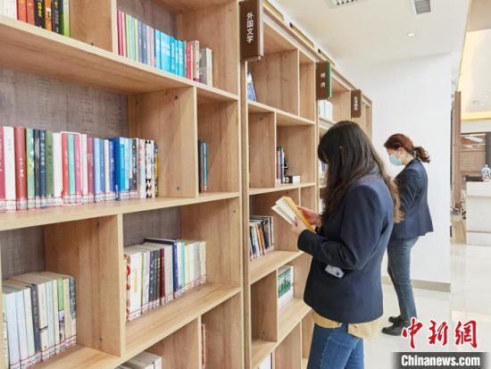 圖為在甘肅公航旅建設(shè)集團有限公司的職工書屋，職工挑選書籍?！⌒煅?攝