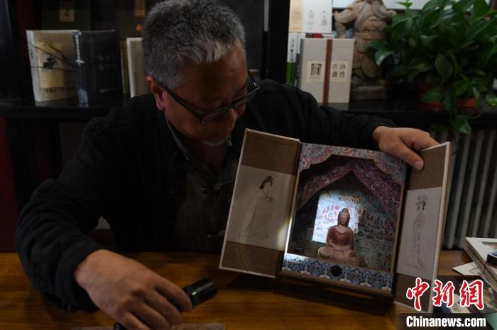 圖為讀者出版集團(tuán)讀者晉林工作室獨(dú)立出品人徐晉林，展示互動(dòng)性強(qiáng)的敦煌題材手工書(shū)。(資料圖) 楊艷敏 攝