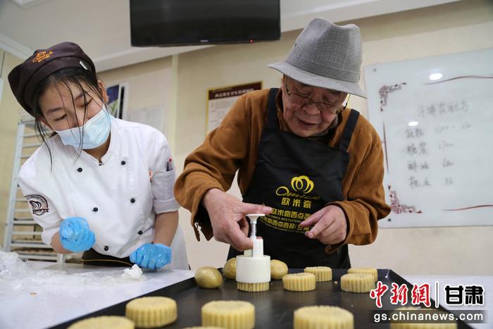 當(dāng)日，受邀參加活動(dòng)的臺(tái)胞臺(tái)屬代表、兩岸婚姻及子女、在甘臺(tái)商代表等歡聚一堂。圖為77歲的在甘臺(tái)胞潘天鑒制作月餅。九美旦增 攝