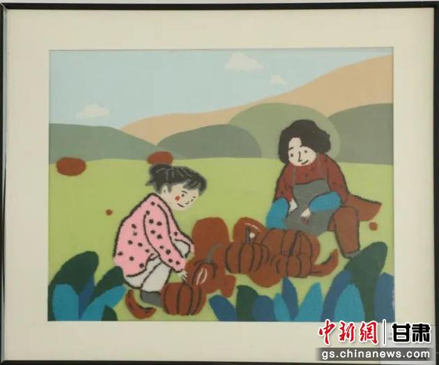 嘉峪關(guān)市新城鎮(zhèn)新城村農(nóng)業(yè)產(chǎn)業(yè)園區(qū)內(nèi)，母女兩人在摘南瓜。刺繡 馬艾米乃 繡稿 敬紅霞