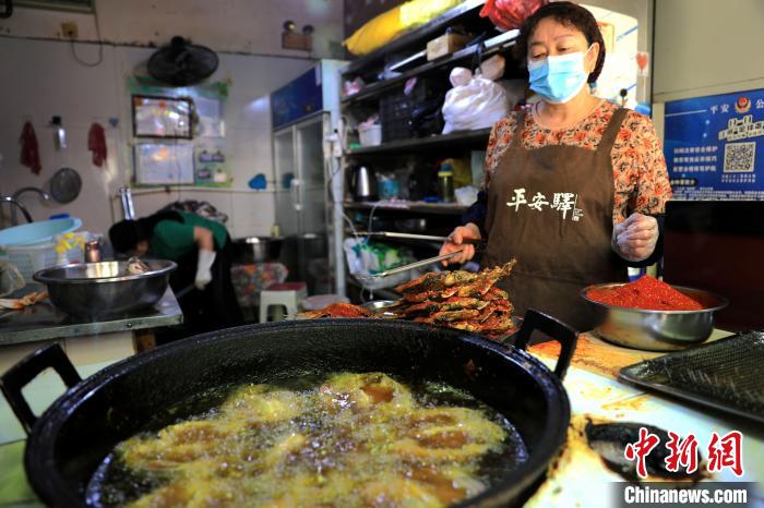 圖為平安驛·河湟民俗文化體驗(yàn)地內(nèi)的商戶炸干板魚?！⊙Φ?攝