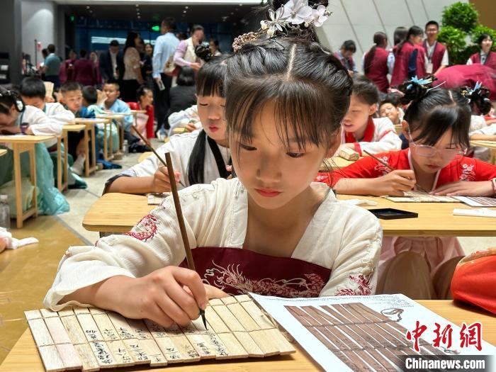 圖為小朋友在甘肅簡(jiǎn)牘博物館練習(xí)書法?！≈行律缬浾?戴文昌 攝