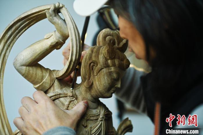 圖為季茂杰進(jìn)行敦煌元素的木雕創(chuàng)作。李亞龍 攝</p>
<p>