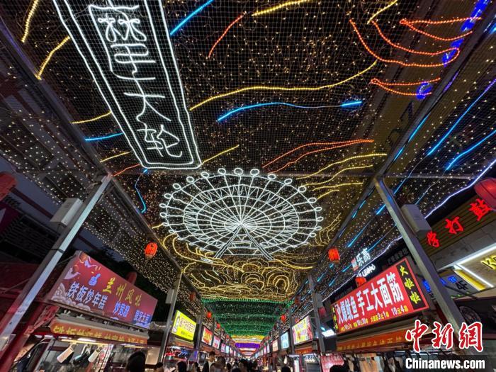 圖為明清街夜市燈光點(diǎn)亮具有武威文化元素的“摩天輪”彩燈?！〈魑牟?攝</p><p>