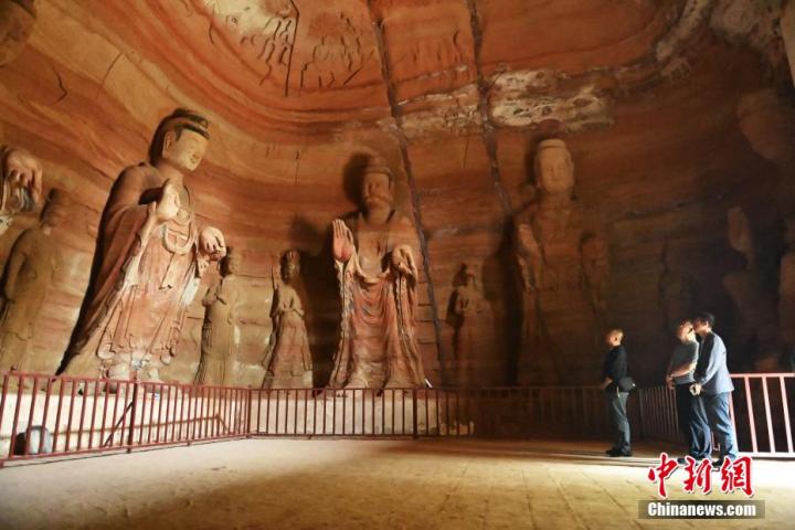 7月15日，游人參觀甘肅省平?jīng)鍪袥艽h百里石窟長(zhǎng)廊中的南石窟寺1號(hào)窟。百里石窟長(zhǎng)廊位于涇川縣境內(nèi)，由512個(gè)石窟、5眼窟中石井組成，現(xiàn)存王母宮石窟、鳳凰山石窟、南石窟寺、丈八寺石窟、羅漢洞石窟、太山寺石窟等規(guī)模較大的石窟群，還有數(shù)量眾多的小石窟群。南石窟寺開鑿于北魏永平三年，其中1號(hào)窟屬于大型七佛窟，七佛高達(dá)6米。中新社記者 李亞龍 攝