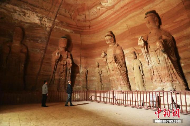 7月15日，游人參觀甘肅省平?jīng)鍪袥艽h百里石窟長(zhǎng)廊中的南石窟寺1號(hào)窟。百里石窟長(zhǎng)廊位于涇川縣境內(nèi)，由512個(gè)石窟、5眼窟中石井組成，現(xiàn)存王母宮石窟、鳳凰山石窟、南石窟寺、丈八寺石窟、羅漢洞石窟、太山寺石窟等規(guī)模較大的石窟群，還有數(shù)量眾多的小石窟群。南石窟寺開鑿于北魏永平三年，其中1號(hào)窟屬于大型七佛窟，七佛高達(dá)6米。中新社記者 李亞龍 攝